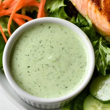 Creamy basil dressing served in a glass jar garnished with fresh basil leaves