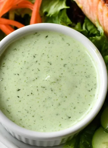 Creamy basil dressing served in a glass jar garnished with fresh basil leaves