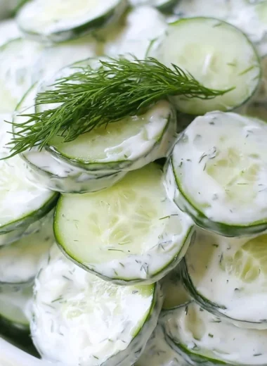 Creamy cucumber salad with onions and a tangy dressing in a bowl