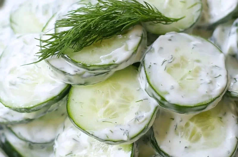 Creamy cucumber salad with onions and a tangy dressing in a bowl