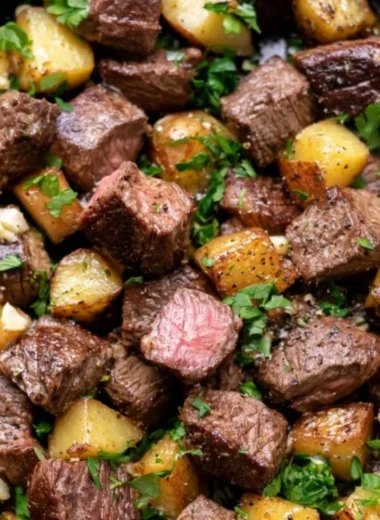 Garlic butter steak bites served with seasoned potatoes on a plate