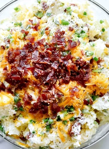Delicious loaded baked potato salad topped with bacon, cheese, and green onions