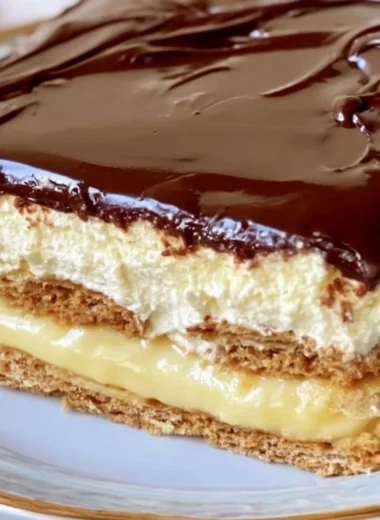 No-bake eclair cake topped with chocolate and whipped cream