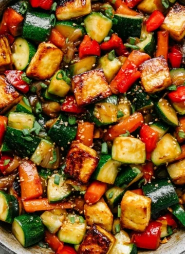Vibrant zucchini stir fry with tofu, garnished with fresh herbs and spices.